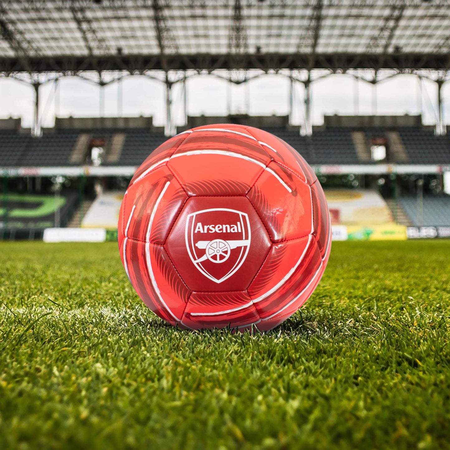 Officially licensed Arsenal F.C. Cyclone football in red and white design with Arsenal logo in a stadium setting.