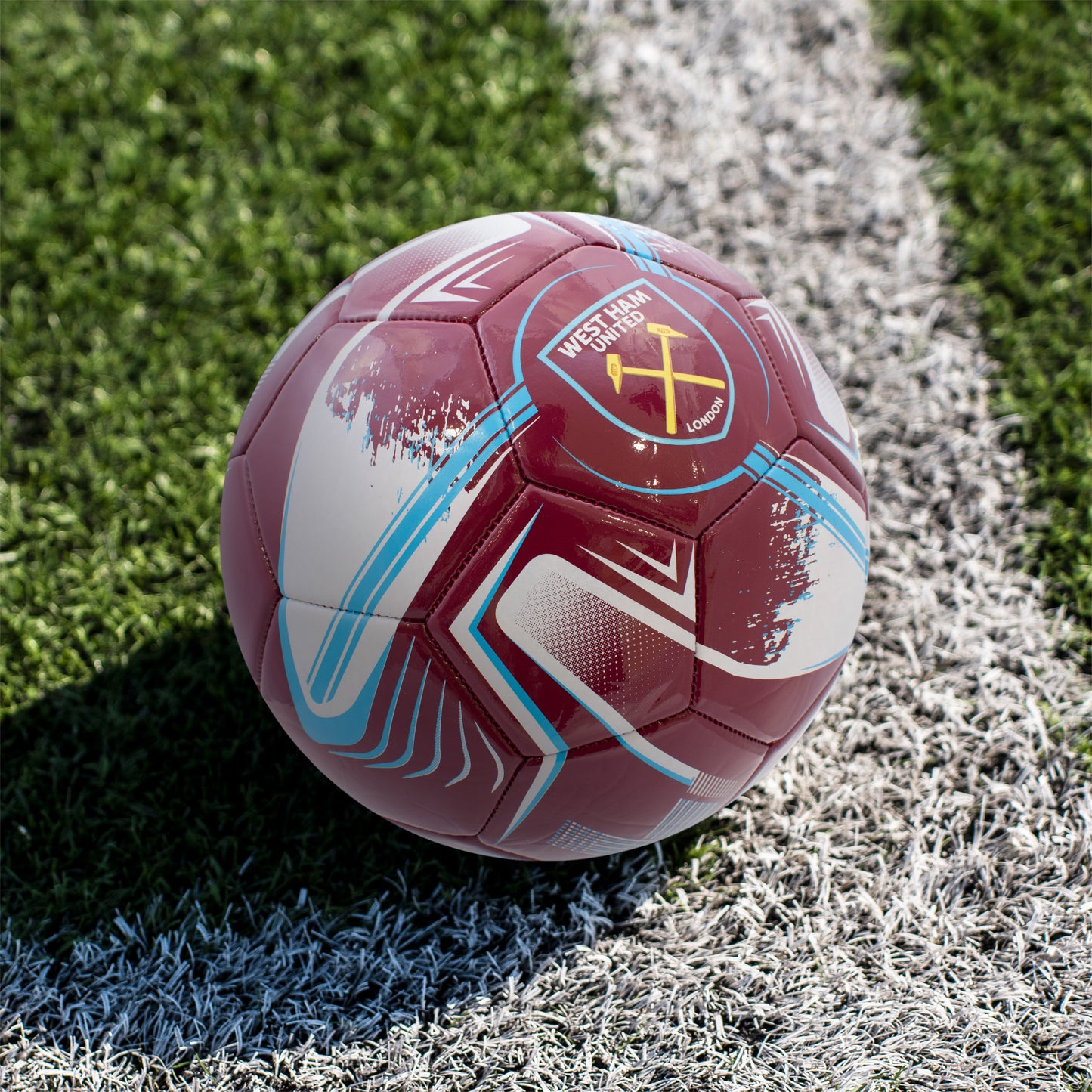 Officially Licensed West Ham F.C. Turbine Football in team colours with focus on a football pitch.