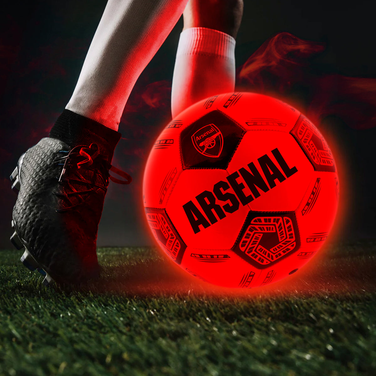 Arsenal Light Up LED Football lit up at night being kicked across a grass football pitch