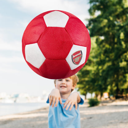 Arsenal Giant 14in Mesh Ball in red and white being thrown by a young boy on a beach towards the camera