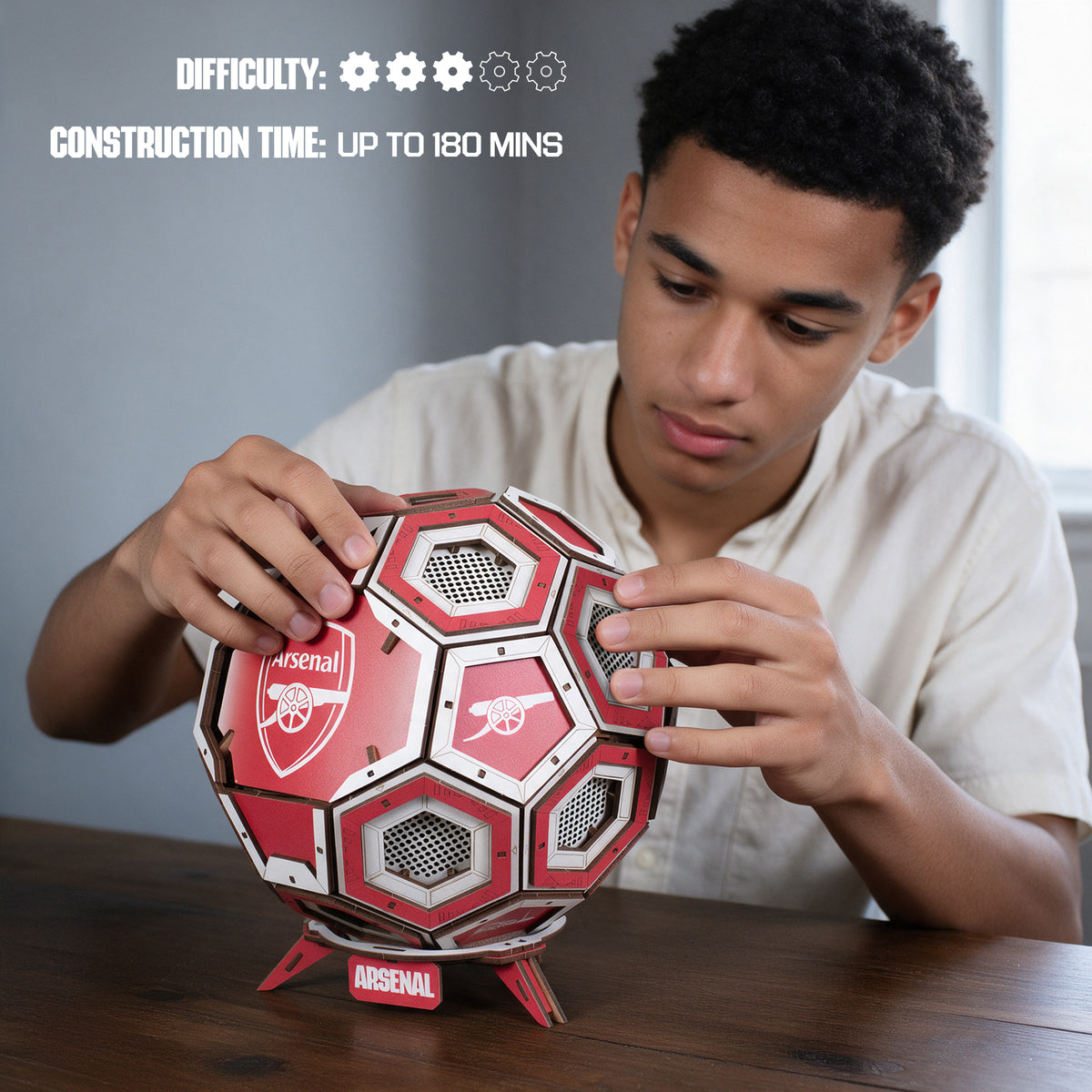 Boy putting together the Arsenal wooden football construction