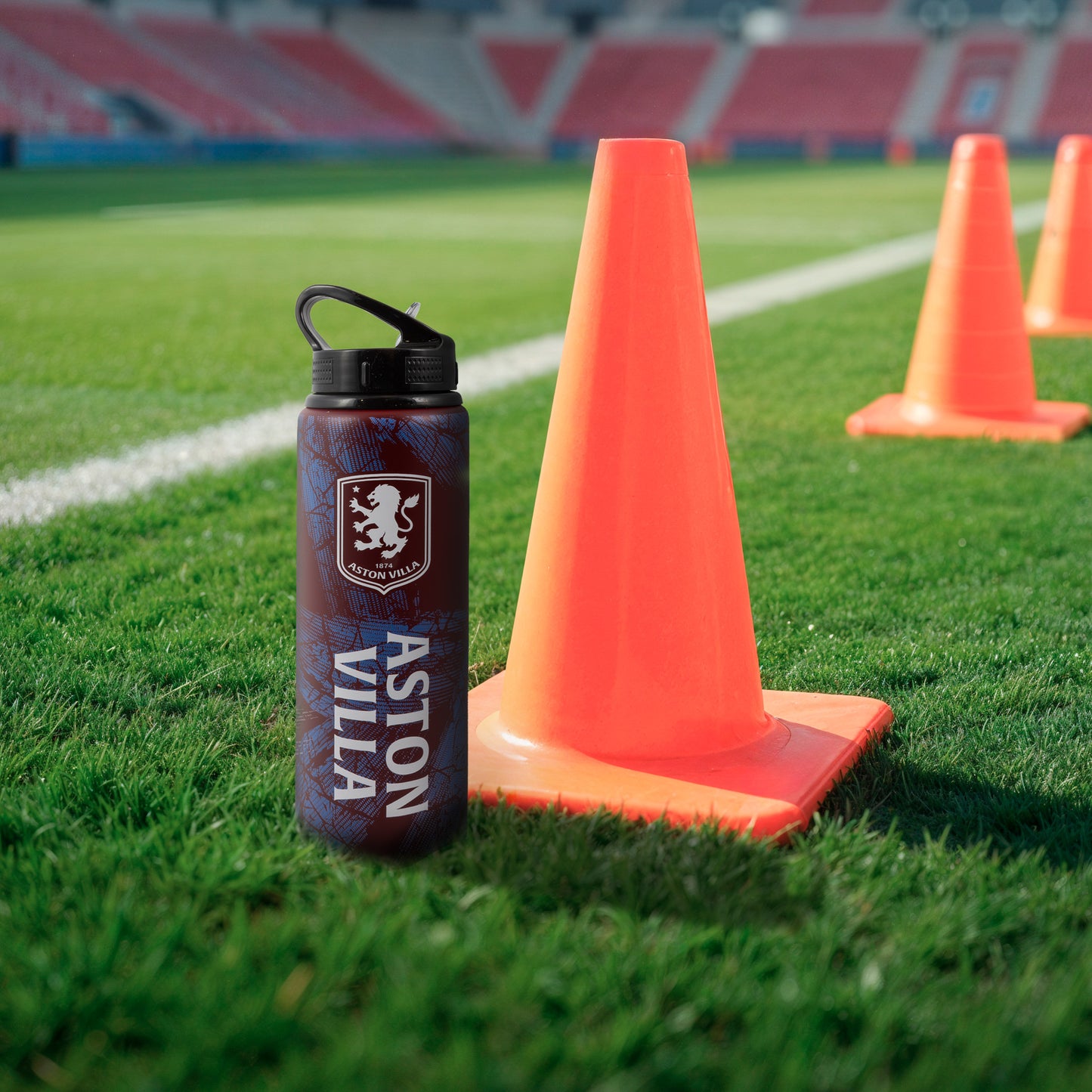Hy-Pro Official Aston Villa water bottle in burgundy with Aston villa branding on a grass football pitch