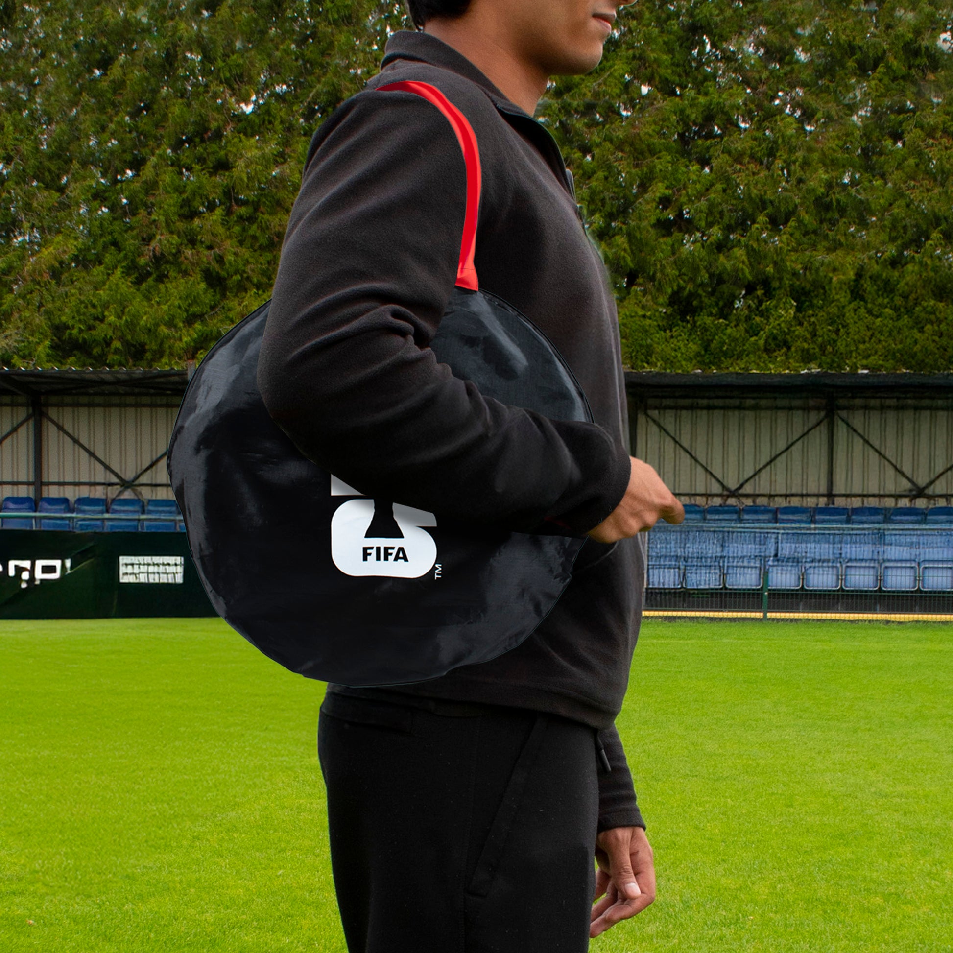 FIFA WORLD CUP 2026 POP UP GOAL BY HY-PRO SPORTS WITH A 26 FIFA BRANDED CARRY BAG OBEING CARRIED ACROSS A FOOTBALL PITCH BY A PLAYER