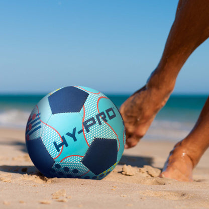 Hy-Pro size 5 Neoprene Football in blue being kicked along a sandy beach