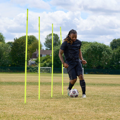 Football player passing a ball through eh Hy-Pro sports agility poles on a football field