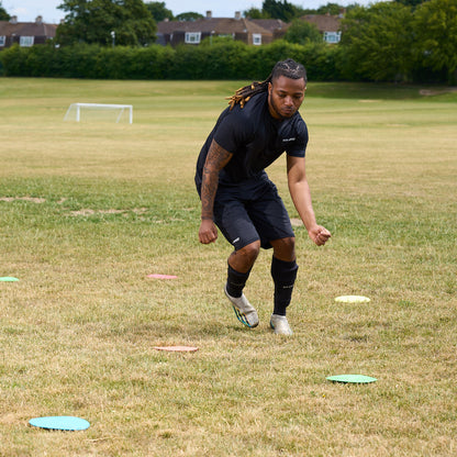 Flat floor Markers with HY-PRO branding being used in a grass field for agility training by a football player