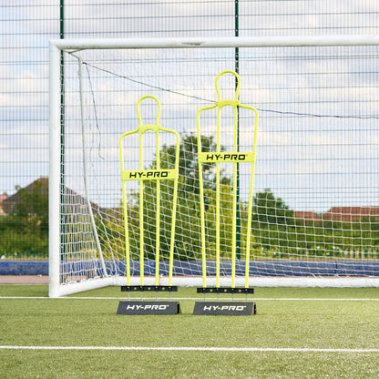 Youth and Adult sized Hy-Pro defender dummy's side by side in front of a football goal on a pitch