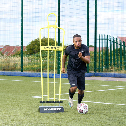 Adult Hy-Pro Defender Dummy with rubber base on an Astroturf pitch with a footballer running past