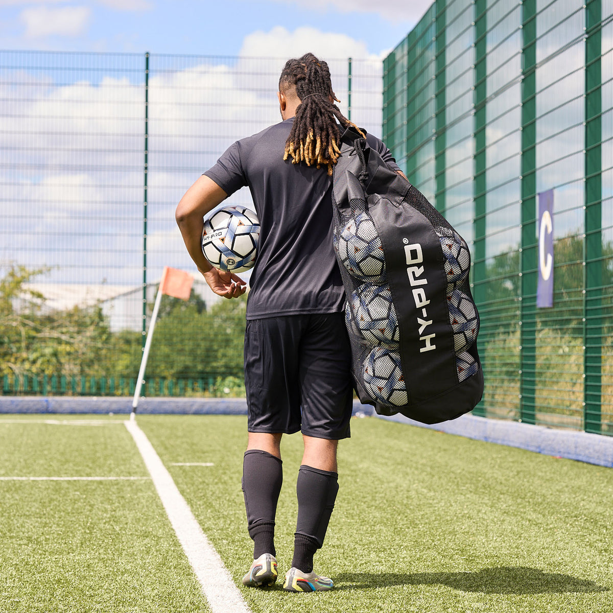 Hy-Pro Sports Jumbo Ball bag being carried across a football pitch by a player