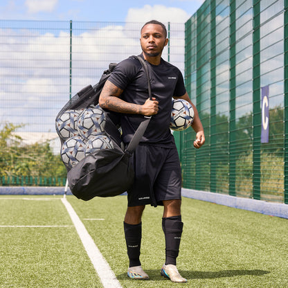 Football player using the HY-PRO Sports Jumbo ball bag to carry footballs across a pitch
