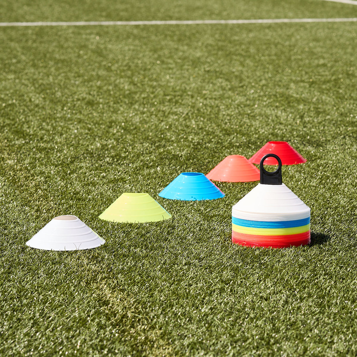 Hy-Pro Sports 50pk of colourful training cones laid out in a line on a grass pitch showing the 5 different colour ways 