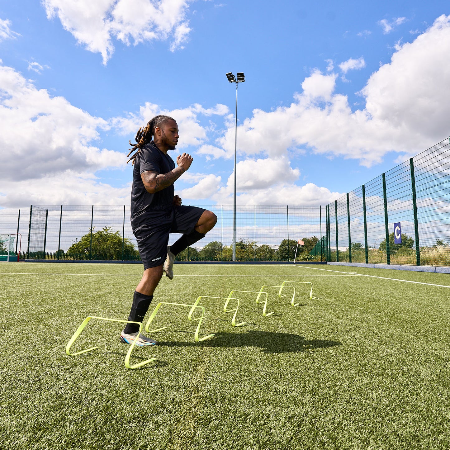 In action shot of a football player using the hy-pro sports yellow agility hurdles