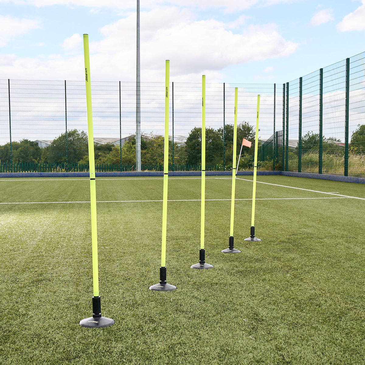 A line of Hy-Pro Sports agility poles and bases on a football pitch 