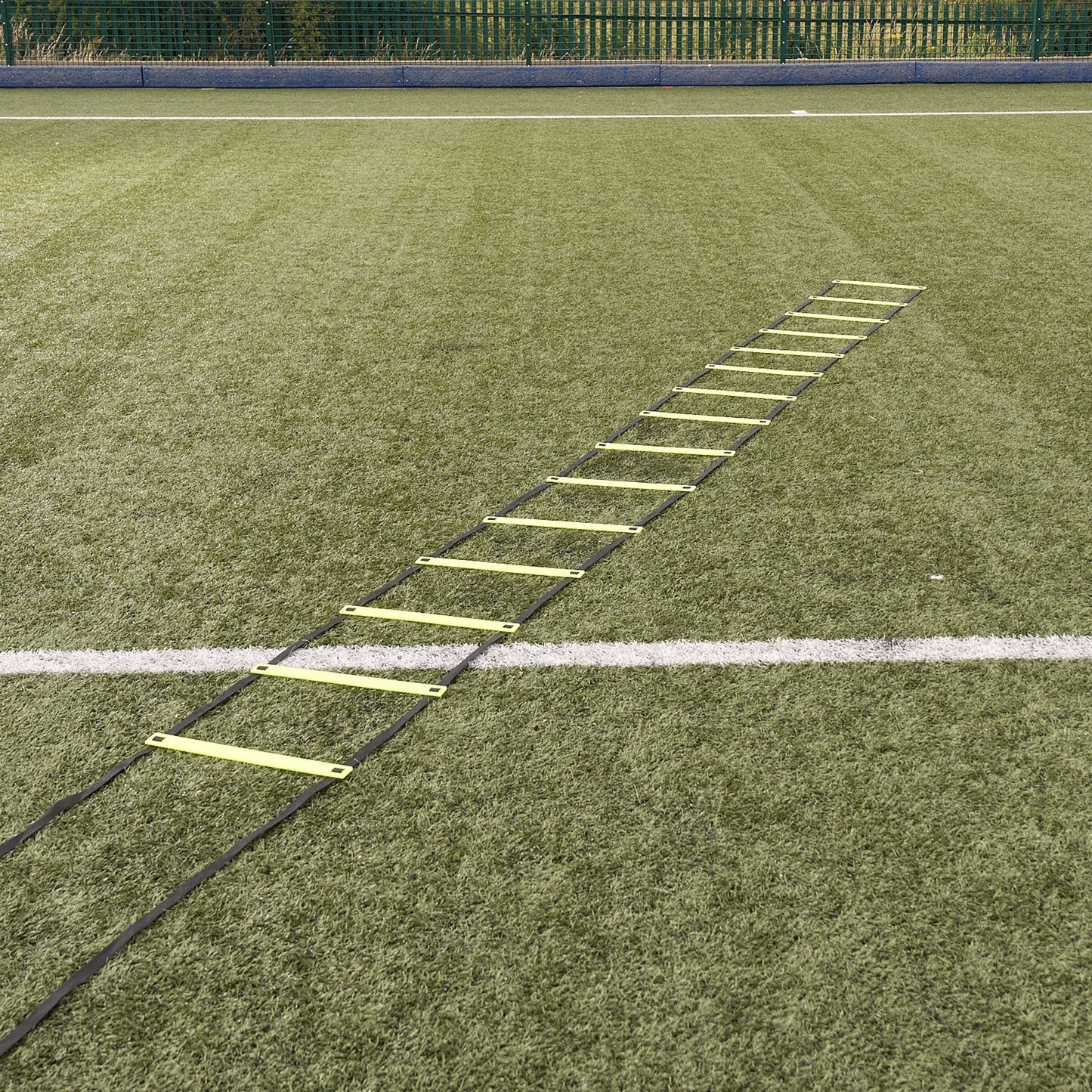 Hy-Pro Sports yellow agility ladder laid out on an Astroturf football pitch