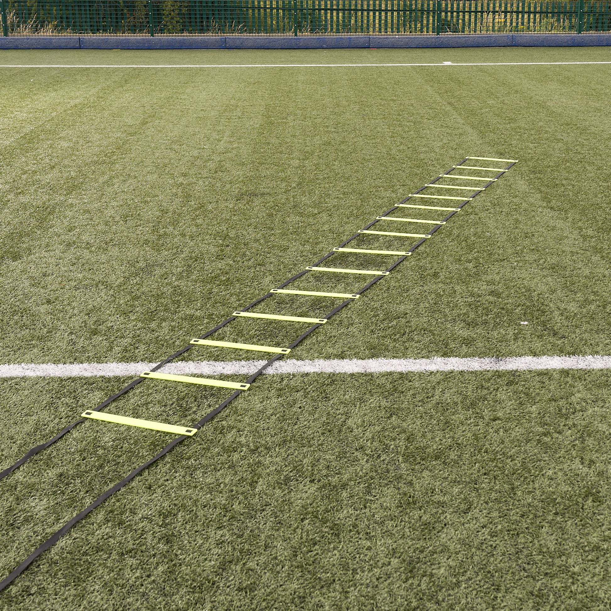 Hy-Pro Sports yellow agility ladder laid out on an Astroturf football pitch