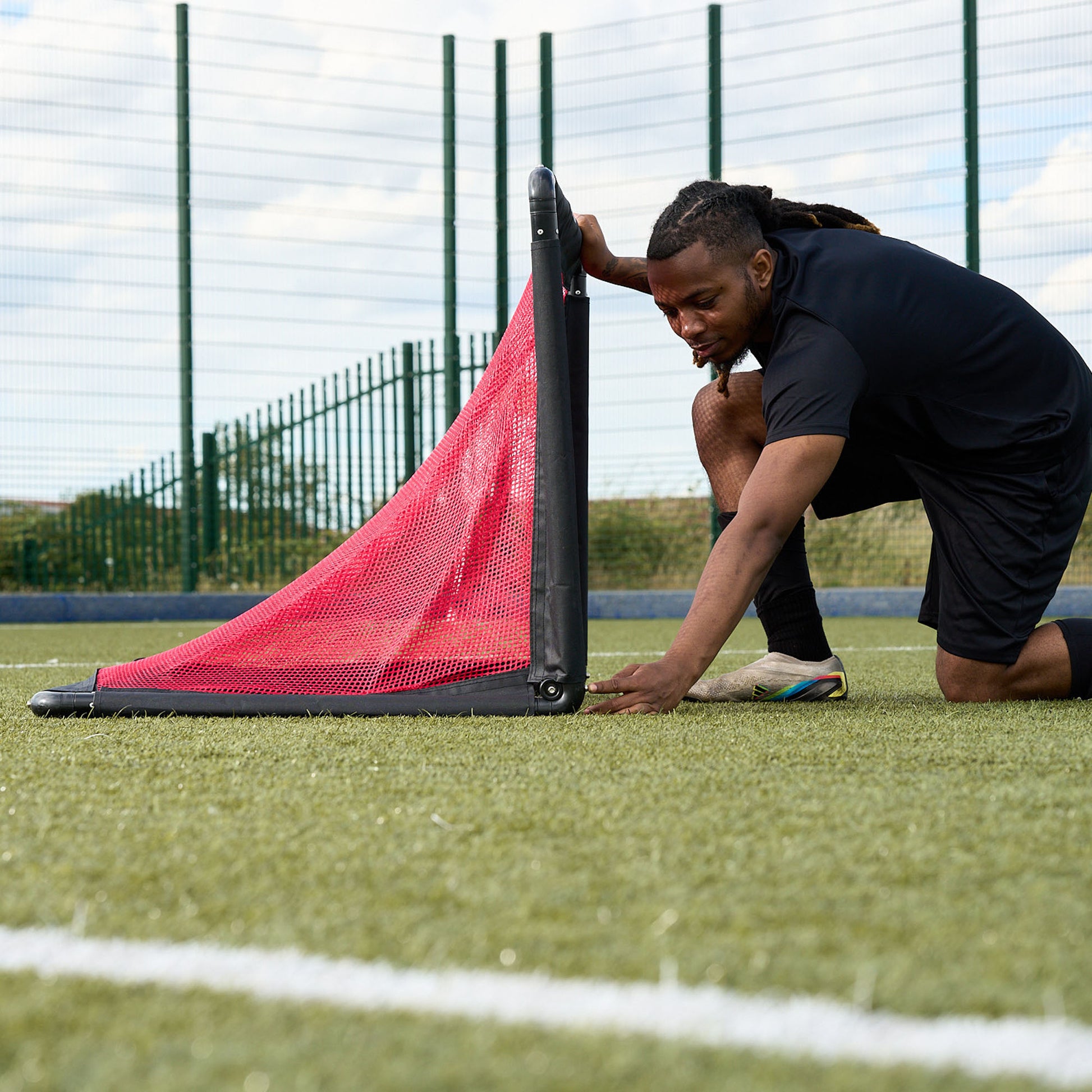Football clicking Alu foldable Hy-Pro goal into place on an Astroturf pitch