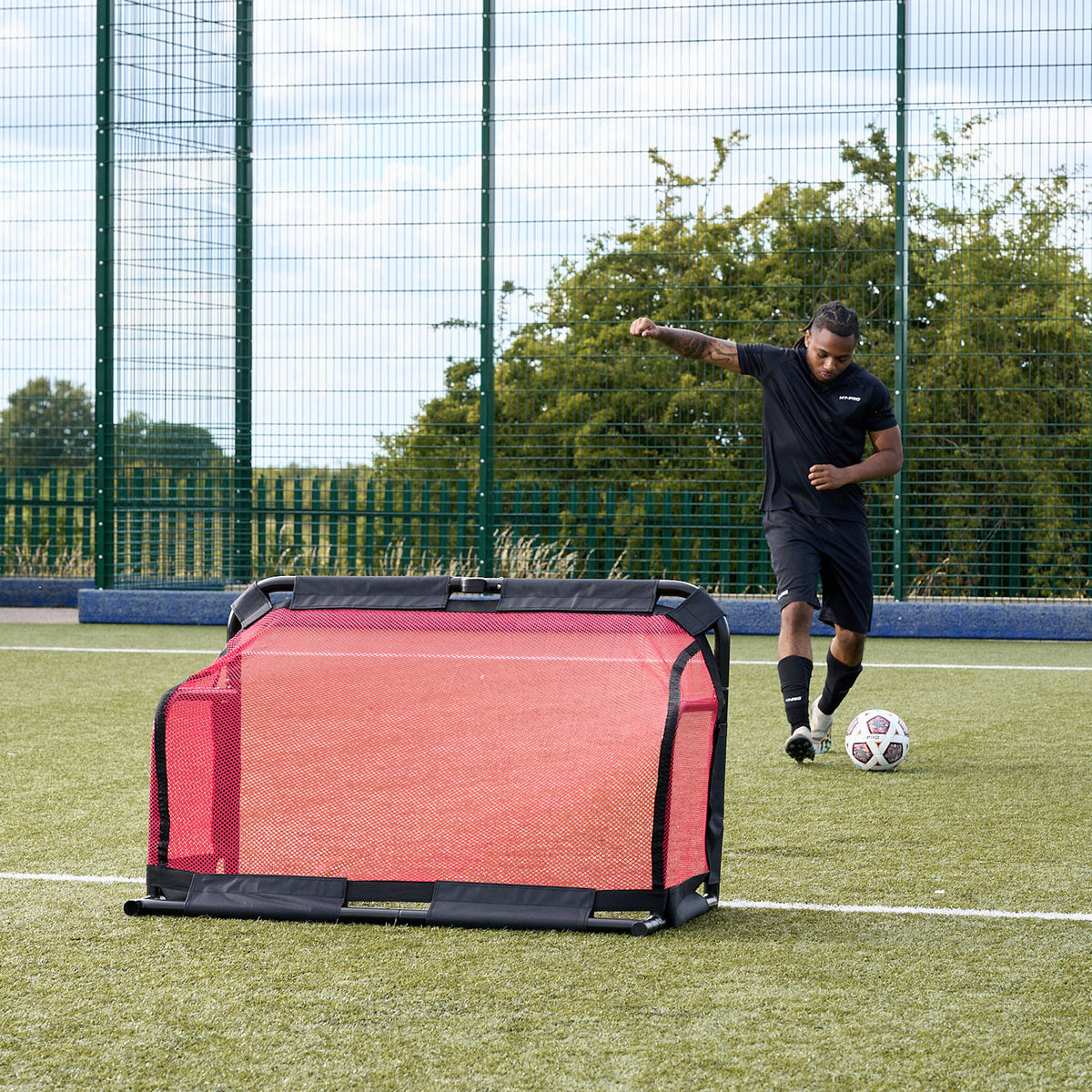 Football goals - Footballer kicking ball towards the Collapsible Hy-Pro 3v3 goal on an Astroturf pitch