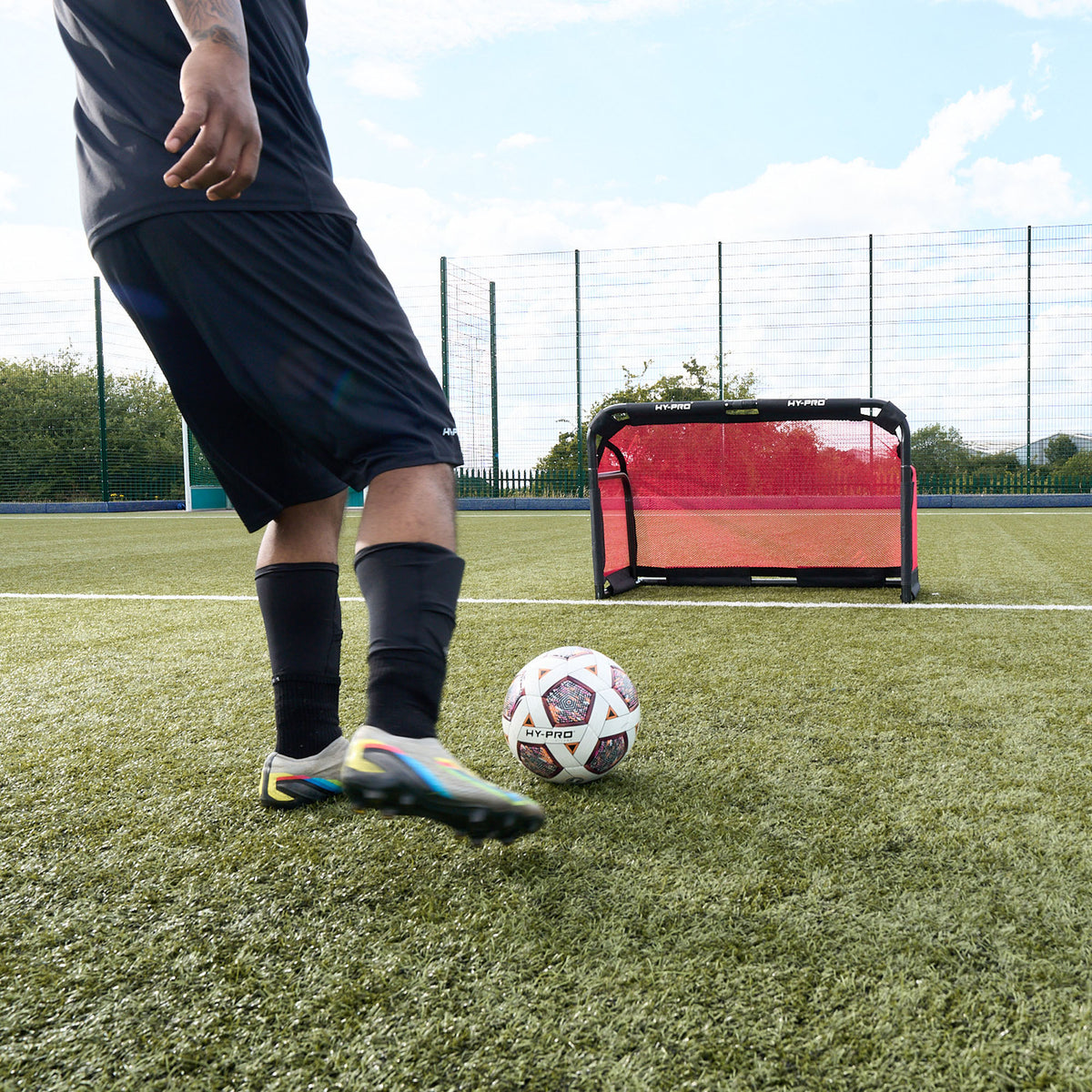 Football goals  - Photo from behind Footballer as he kicks FIFA Quality approved football ball towards the Collapsible Hy-Pro 3v3 goal on an Astroturf pitch