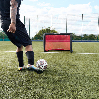 Footballer kicking football towards Hy-Pro Alu foldable goal on a football pitch 