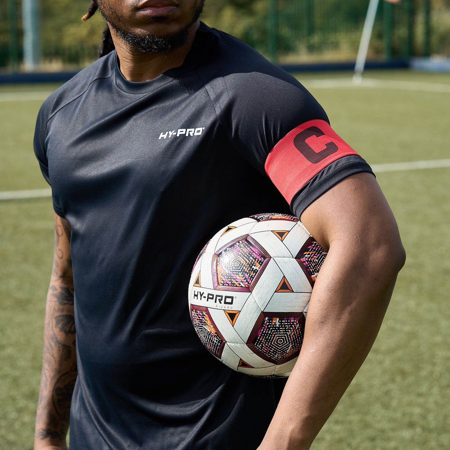 Hy-Pro Official FIFA Quality Approved, Match, Size 5 Football ball under the arm of a player wearing a captains armband 