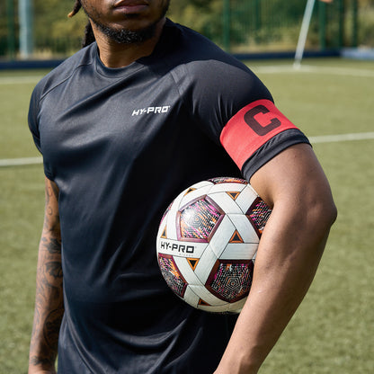 Hy-Pro Official FIFA Quality Approved, Match, Size 5 Football ball under the arm of a player wearing a captains armband 