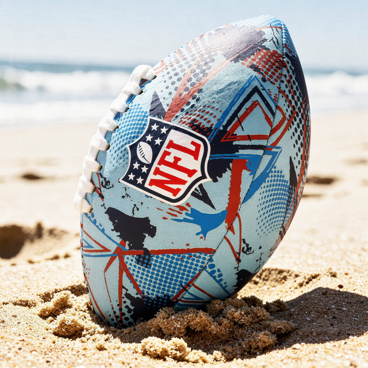 NFL Neoprene football in blue and red with NFL logo on a sandy beach